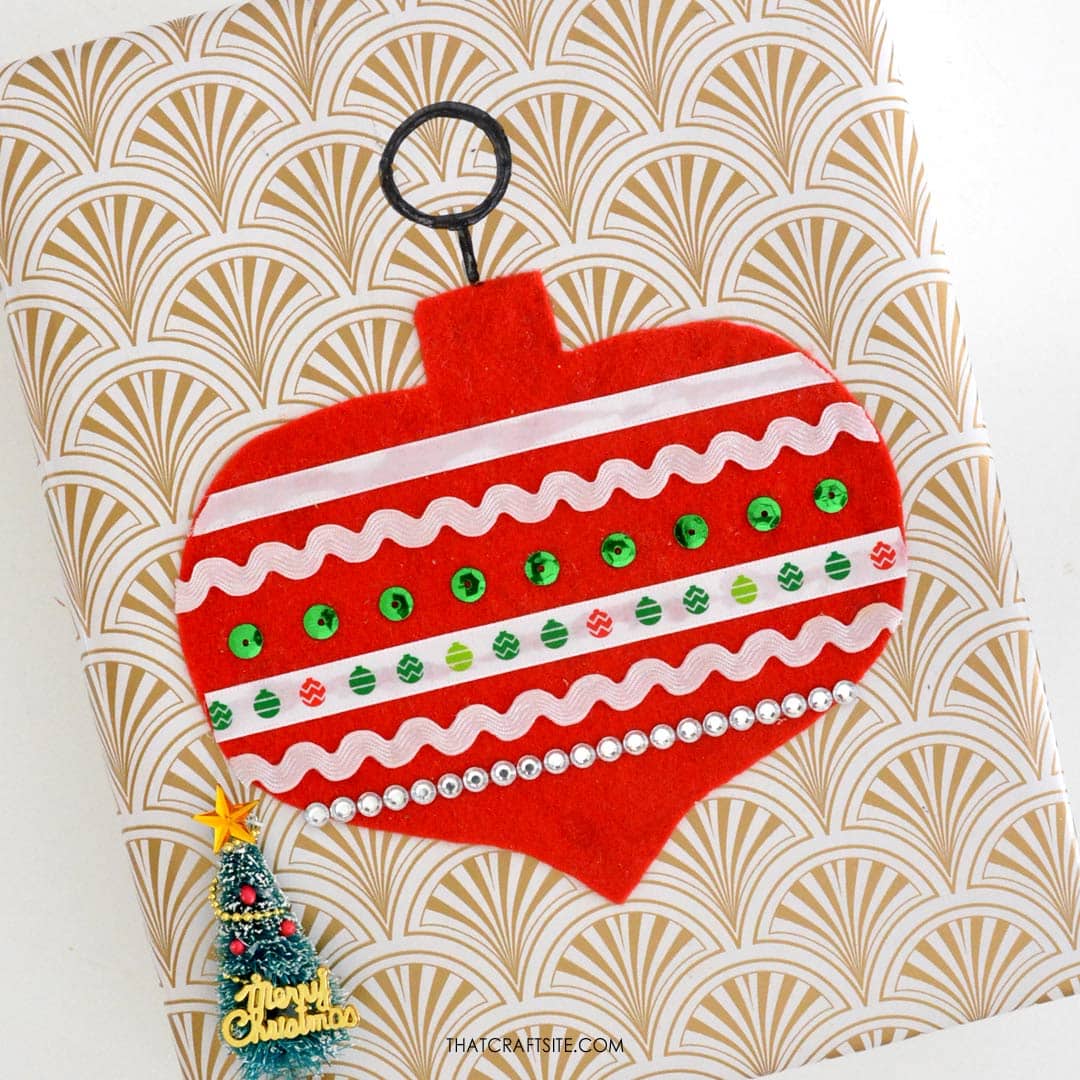 How to Decorate Christmas Gift Wrap with DIY Felt + Ribbon Ornament Step 3: Glue ribbons on and draw ornament hanger with black marker. thatcraftsite.com.