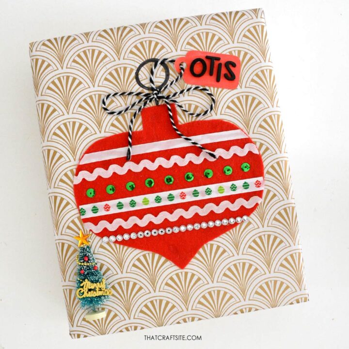 How to Decorate Christmas Gift Wrap with DIY Felt + Ribbon Ornament Step 4: Attach gift tag with string bow. thatcraftsite.com.