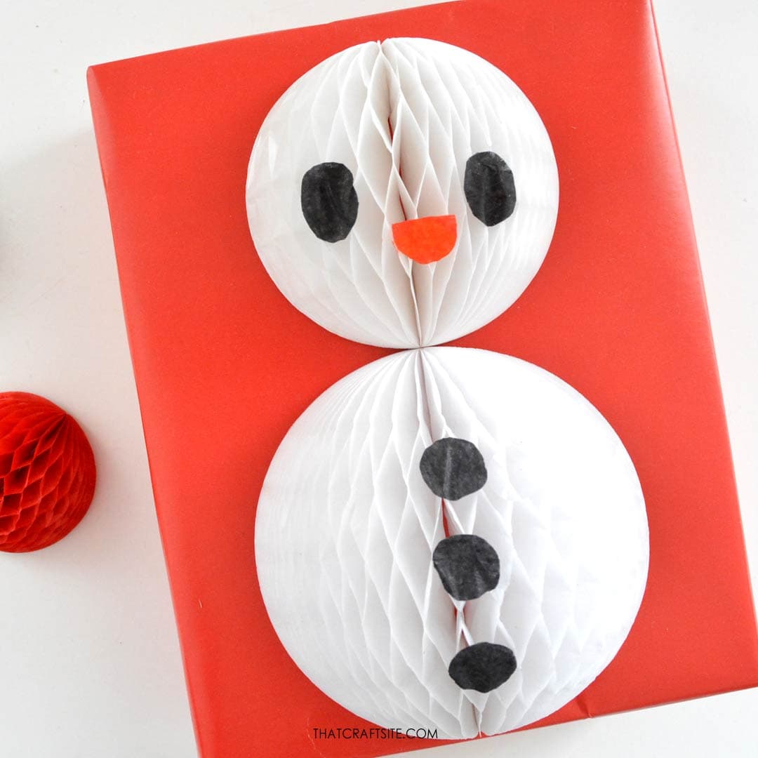 DIY honeycomb snowman Christmas gift wrap step 3: Cut and glue on paper face features. thatcraftsite.com.