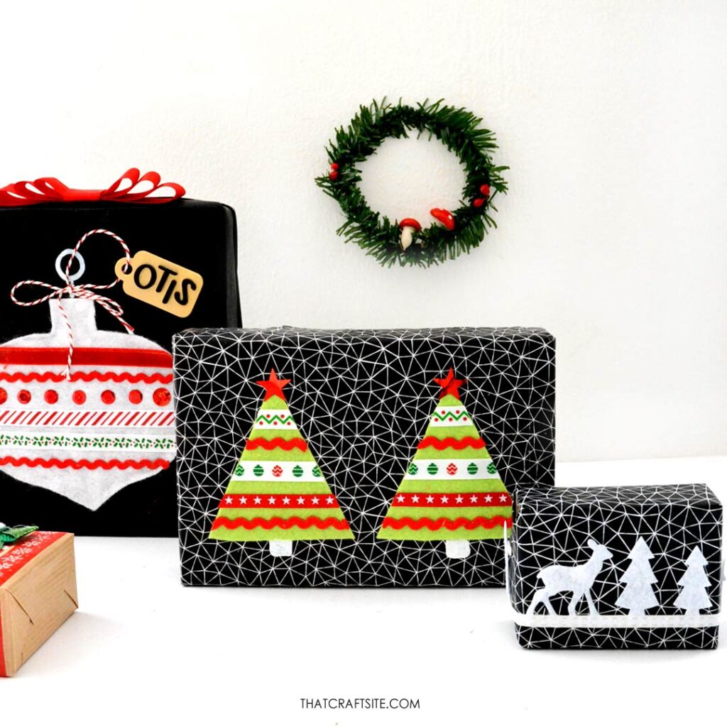Group of pretty Christmas gifts decorated with DIY felt and ribbon ornament and Christmas trees. Small Christmas wreath on background. thatcraftsite.com.