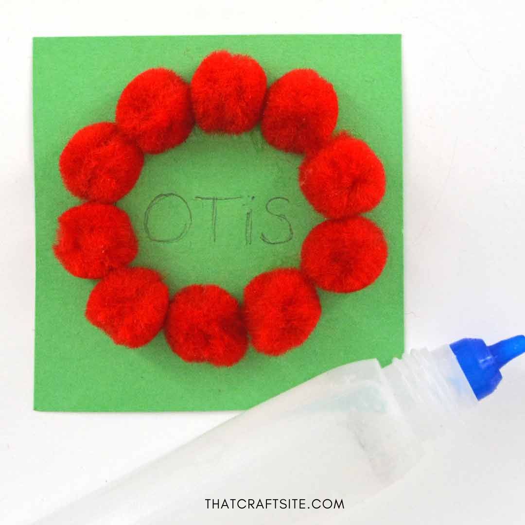 DIY mini pom pom wreath gift tag. Step 3: Glue small pompoms on circle. thatcraftsite.com.
